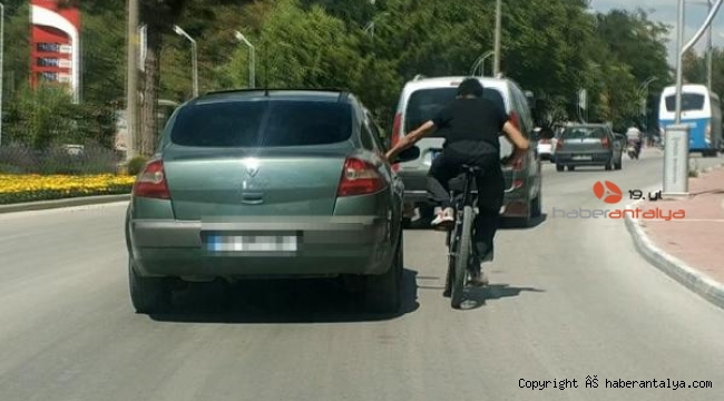 İlginç anlar. Otomobil kapısına tutunan bisikletli ile devam etti