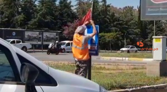 Yerde bulduğu Türk bayrağını temizleyip, tabelaya astı