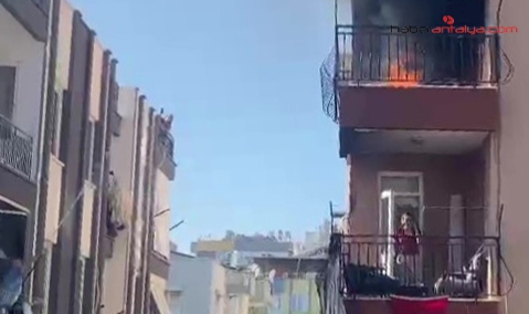Yangını gören komşular karşı balkondan hortumla alevlere müdahale etti