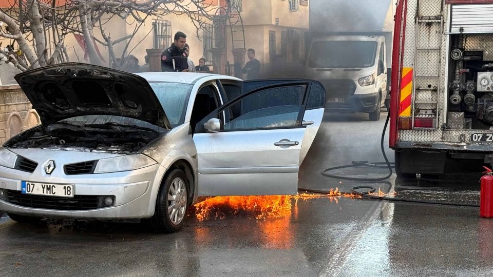 Yanan otomobili hortumla söndürmeye çalıştı