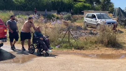 Evine yaklaşan alevlerden kurtarılan kadın tekerlekli sandalyeyle bölgeden uzaklaştırıldı