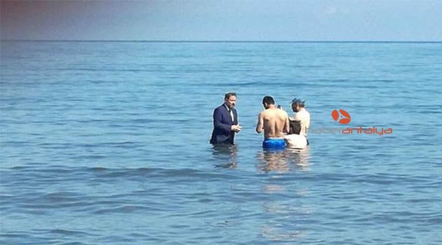 Milletvekili adayı takım elbise ile denize girip, yüzenlerden oy istedi