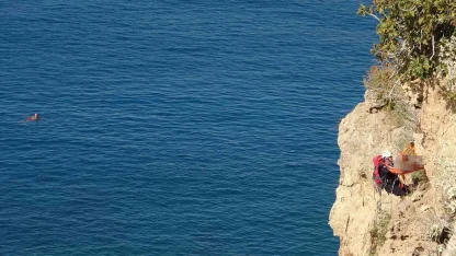 Falezlerde ölü bulunan adamın cenazesinin 2 saat süren alınma operasyonunu yüzerek izlediler