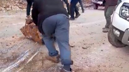 Yola düşen kayaları iple araca bağlayıp çektiler